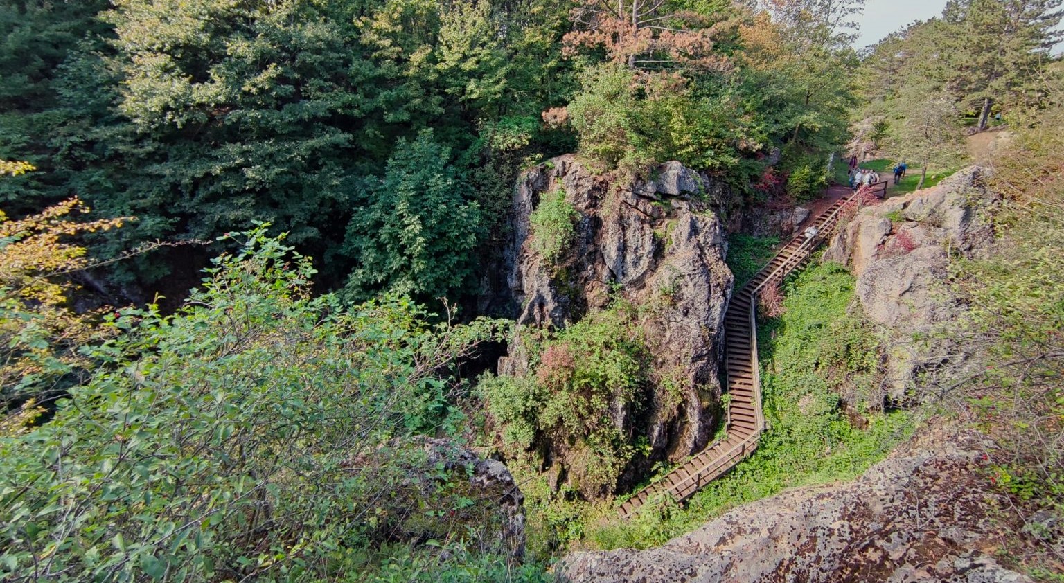 Óriási mészkőfalak mellett kanyargó falépcső vezet a mélybe a magyar sziklakatlanban